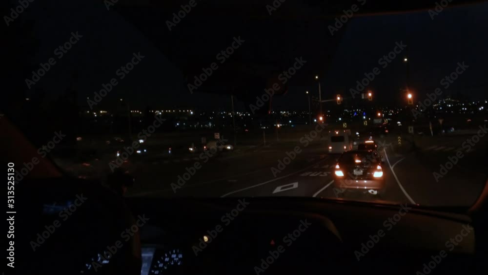 view from the passenger compartment through the windshield, the dashboard of a car, moving vehicles, road markings, traffic lights and parking lights at night time view from the passenger compartment through the windshield, the dashboard of a car, moving vehicles, road markings, traffic lights and parking lights at night time