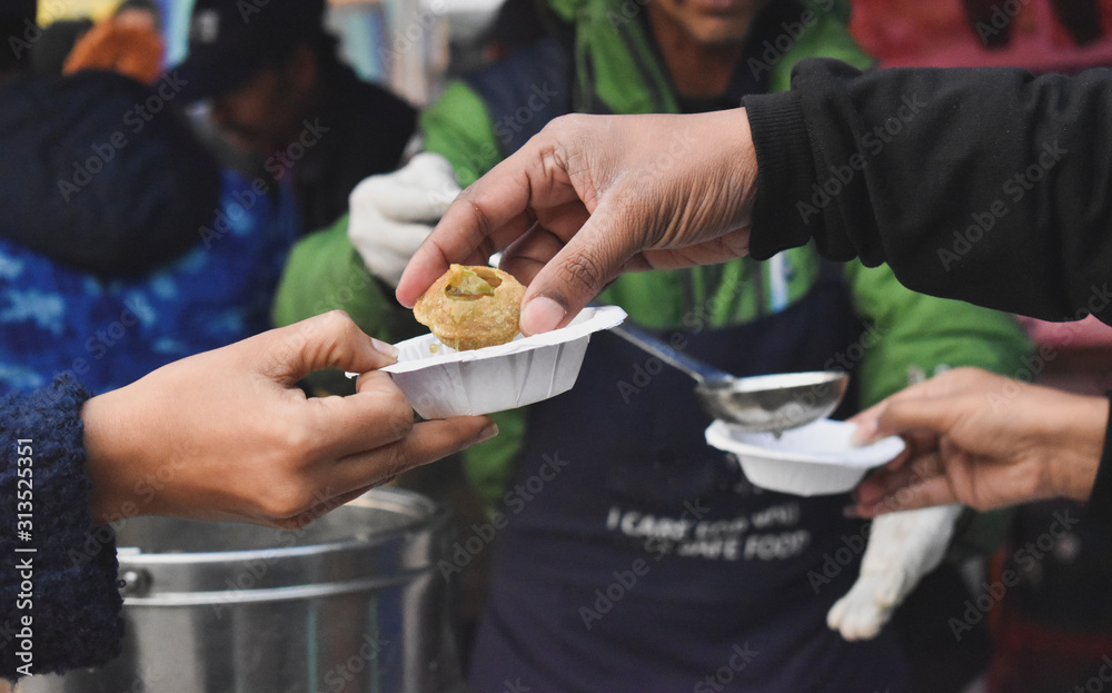 Fototapeta premium Vendor serving gol gappa at market stall