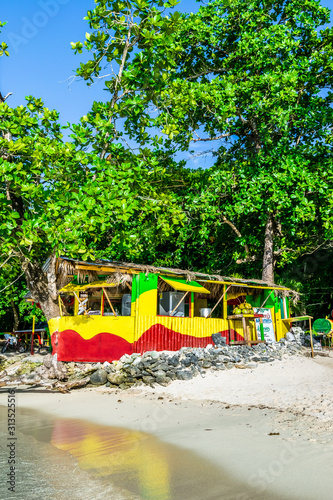 Portland, Jamaica. Traditional colorful bamboo outdoor vendor cook shop on Winnifred Beach. Jamaican food/meals cooked on open fire pot as well as grill/jerk pan for chicken, pork, fish.