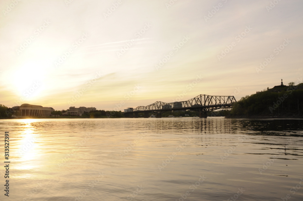 Obraz premium sunset on the river with bridge in the distance