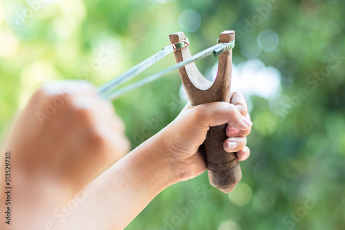Human pulling slingshot and ready to fire. Fototapet