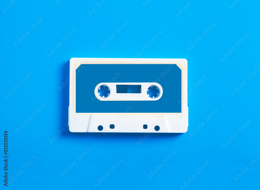 Retro cassette tape on blue background, top view.