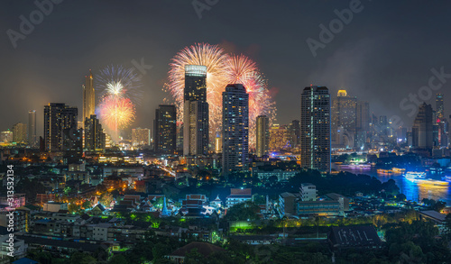 Fantastic Multicolor Firework exploding over the panorama of Bangkok Cityscape river side for Celebration  Business architecture and celebration and happy new year and merry christmas concept