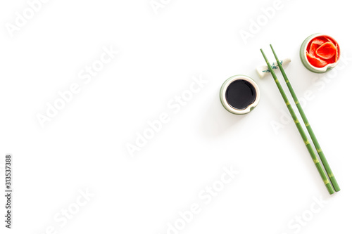 Set of chopsticks for sushi, ginger and soy sause on white background top-down frame copy space © 279photo