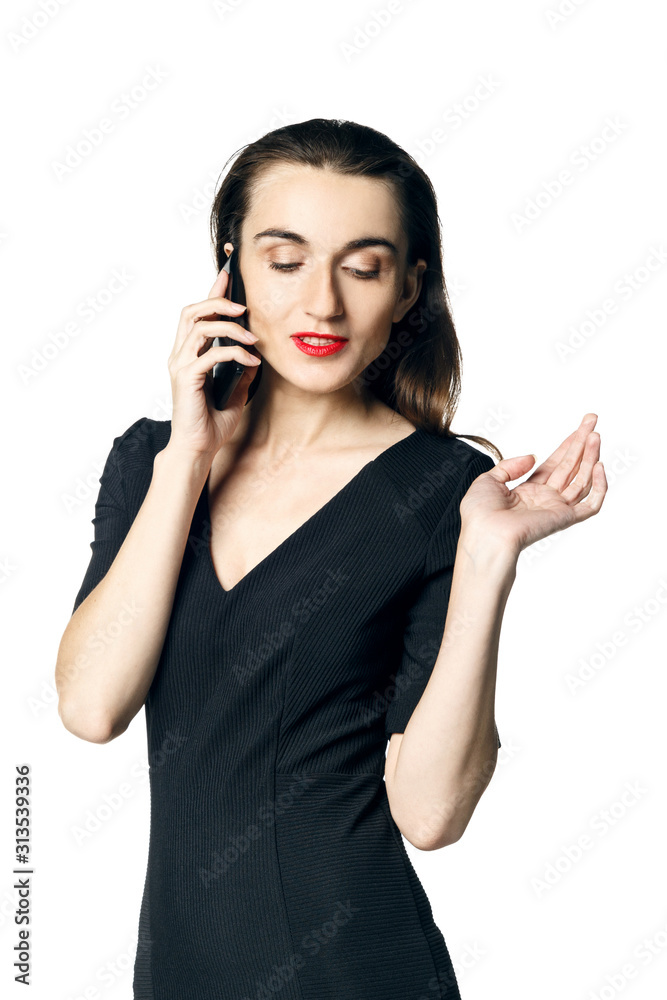 Business woman (fatal woman) in a black dress with red lipstick talking on the phone, isolated on a white background. Business woman (fatal woman) in a black dress with red lipstick talking on the phone, isolated on a white background.