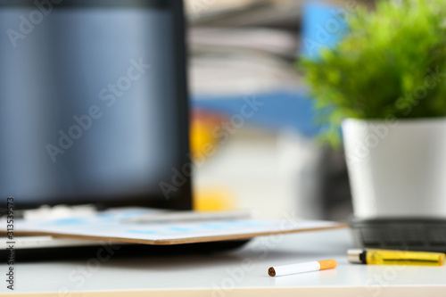 Cigarette and lighter lying at worktable