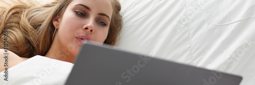 woman work winh laptop stay in bed early morning photo