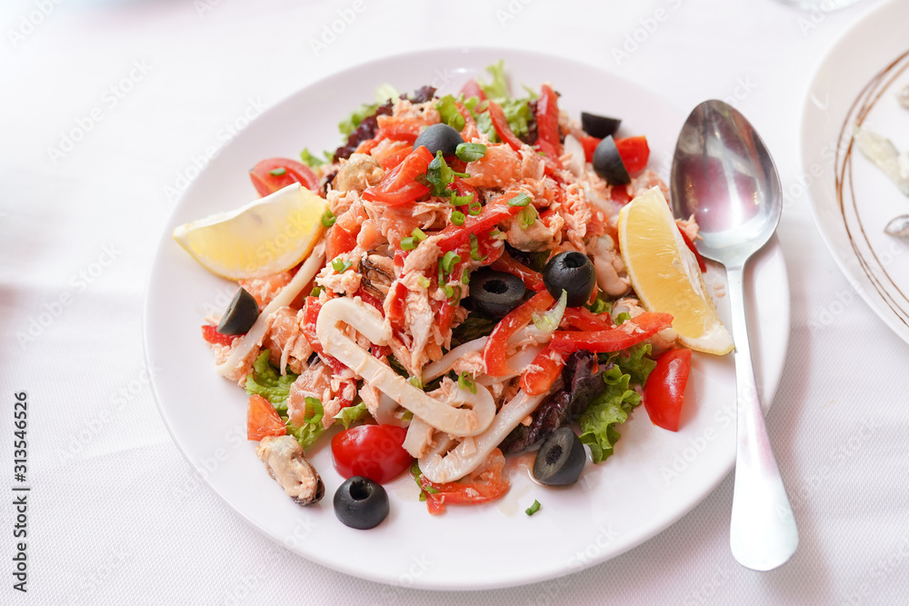 Salad with seafood, red pepper, olives and lemon. Top view.