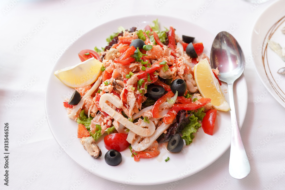 Salad with seafood, red pepper, olives and lemon. Top view. Salad with seafood, red pepper, olives and lemon. Top view.