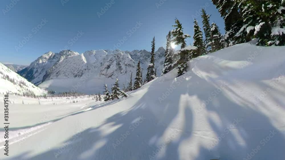 POV: Awesome first person shot of snowboarding off piste in the gorgeous Canadian mountains. Shredding the fresh powder snow during a heliboarding trip in British Columbia. Beautiful wintry landscape. POV: Awesome first person shot of snowboarding off piste in the gorgeous Canadian mountains. Shredding the fresh powder snow during a heliboarding trip in British Columbia. Beautiful wintry landscape.