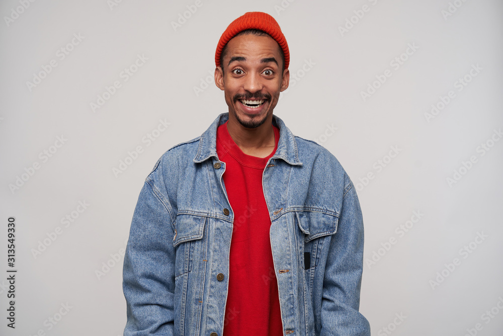 Studio photo of joyful young bearded dark skinned brunette guy in casual clothes raising surprisedly eyebrows while looking at camera with wide eyes and mouth opened, isolated over white background Studio photo of joyful young bearded dark skinned brunette guy in casual clothes raising surprisedly eyebrows while looking at camera with wide eyes and mouth opened, isolated over white background