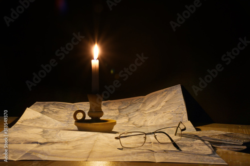 La cartina sulla tavola illuminata dalla fiamma della candela photo