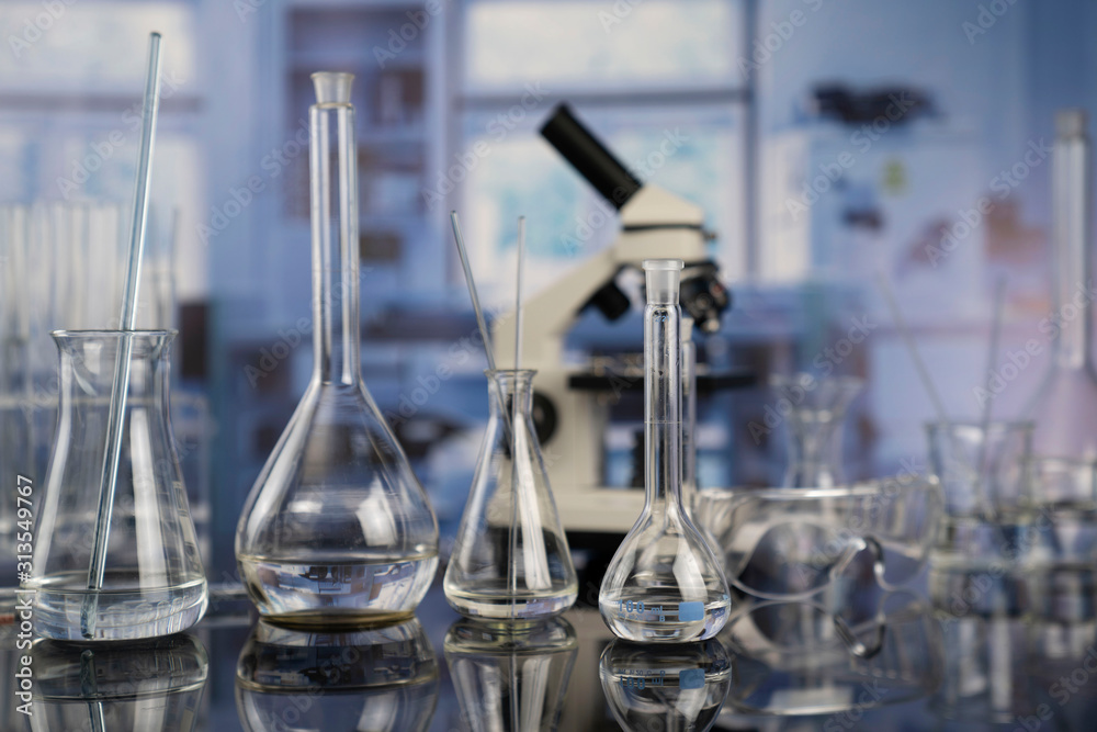 Modern scientific laboratory interior. Laboratory glassware and microscope on the glass table. Modern scientific laboratory interior. Laboratory glassware and microscope on the glass table.