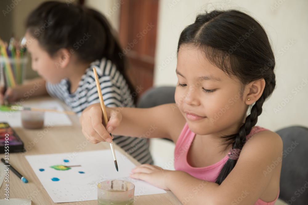 group little girl with brush painting on table in School, education, cut girl painting in at her home. Selective focus and small depth of field, Painting with watercolor, drawing, Creativity concept. group little girl with brush painting on table in School, education, cut girl painting in at her home. Selective focus and small depth of field, Painting with watercolor, drawing, Creativity concept.