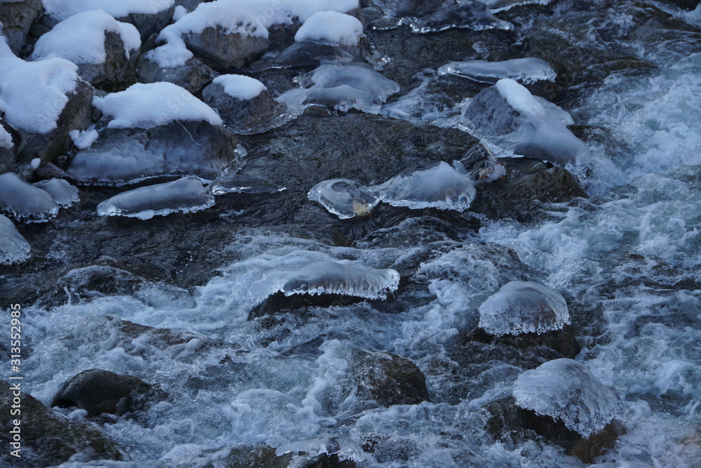 Eiszapfen und Eisflächen an Gebirgsbach