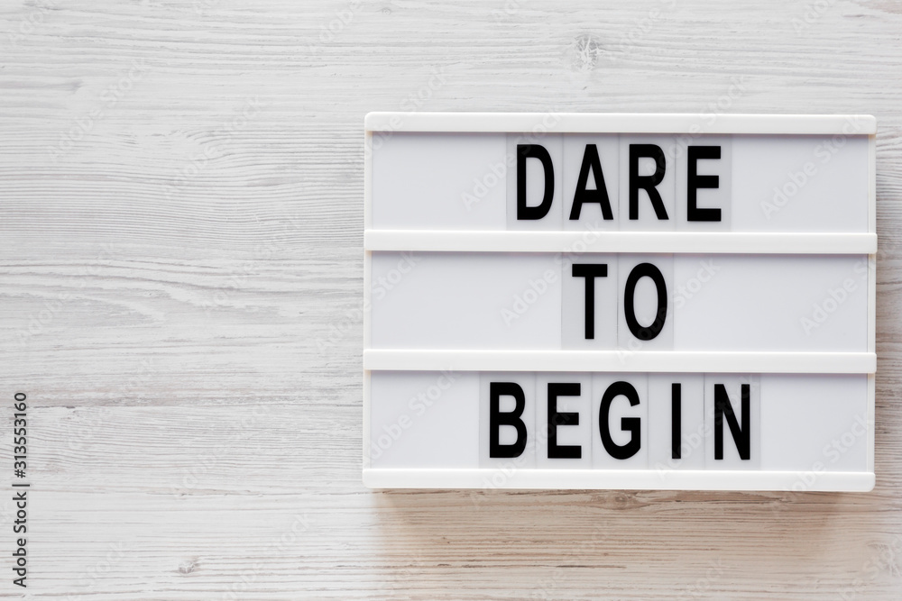 'Dare to begin' words on a lightbox on a white wooden background, top view. Overhead, from above, flat lay. Copy space. 'Dare to begin' words on a lightbox on a white wooden background, top view. Overhead, from above, flat lay. Copy space.