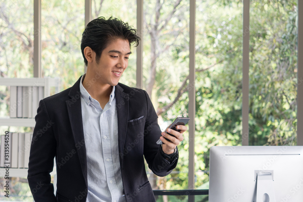 Asian businessman are happy hold hand telephone send emails to clients to contact work in the office.Play games,social media,type text.The green tree background in the garden and copy space Asian businessman are happy hold hand telephone send emails to clients to contact work in the office.Play games,social media,type text.The green tree background in the garden and copy space