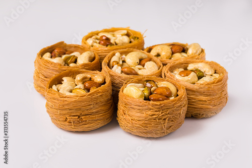 Oriental sweets, baklava, Turkish delight with almonds, cashews and pistachios on plates.