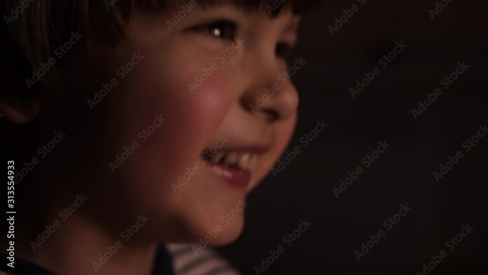 Portrait Сute Little Kid While Watching TV. Young Boy Watch Television on Living Room. Concept Video Game, Entertainment, Emotions, Family. Child Watching TV, Close up Face of Little Boy, Kid Eyes. Portrait Сute Little Kid While Watching TV. Young Boy Watch Television on Living Room. Concept Video Game, Entertainment, Emotions, Family. Child Watching TV, Close up Face of Little Boy, Kid Eyes.