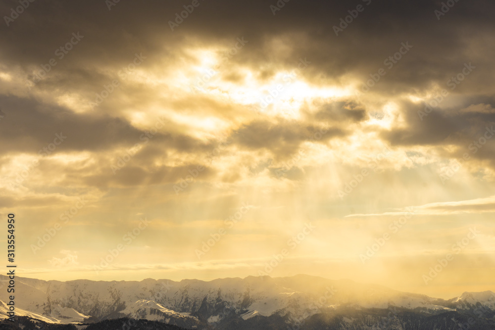 Sun rays of light on snow-capped mountain peaks Sun rays of light on snow-capped mountain peaks