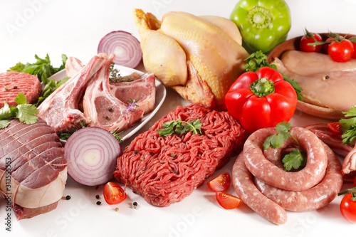 assorted of raw meats on white background- roast beef, sausage, minced beef, chicken, lamb chop