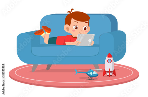 happy cute kid boy use tablet on sofa
