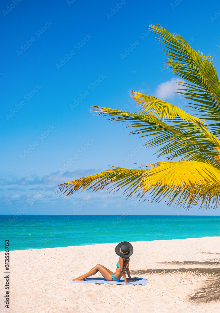 Caribbean beach tourist relaxing in Barbados, cruise shore day. Woman sunbathing sun tanning under palm tree on sand on Dover beach, famous resort tourist tropical destination. - obrazy, fototapety, plakaty 