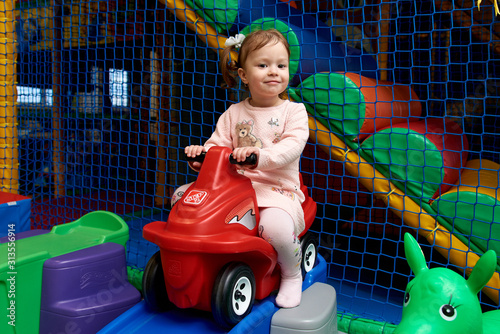 Cute little girl on run bike at kid zone