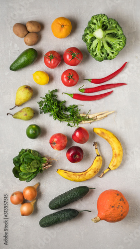Vegetarian food. Fresh vegetables, root vegetables and fruits on a gray concrete background. Flat lay, food photo.