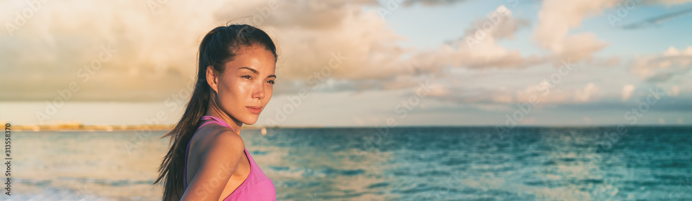 Asian young woman relaxing on beach watching sunset over ocean panoramic banner.