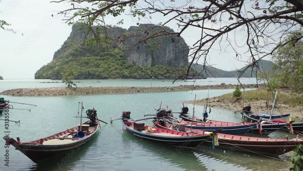 Local fishing boats floating on water sea near coast with Green Island Mountain Landscape in South of Thailand Local fishing boats floating on water sea near coast with Green Island Mountain Landscape in South of Thailand