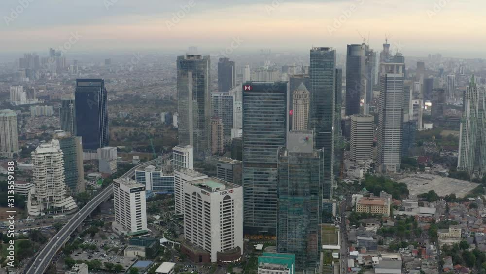 Aerial view of skyscrapers in Jakarta with building in construction before beautiful sunset and cloudy sky. Fast Dolly motion Aerial view of skyscrapers in Jakarta with building in construction before beautiful sunset and cloudy sky. Fast Dolly motion