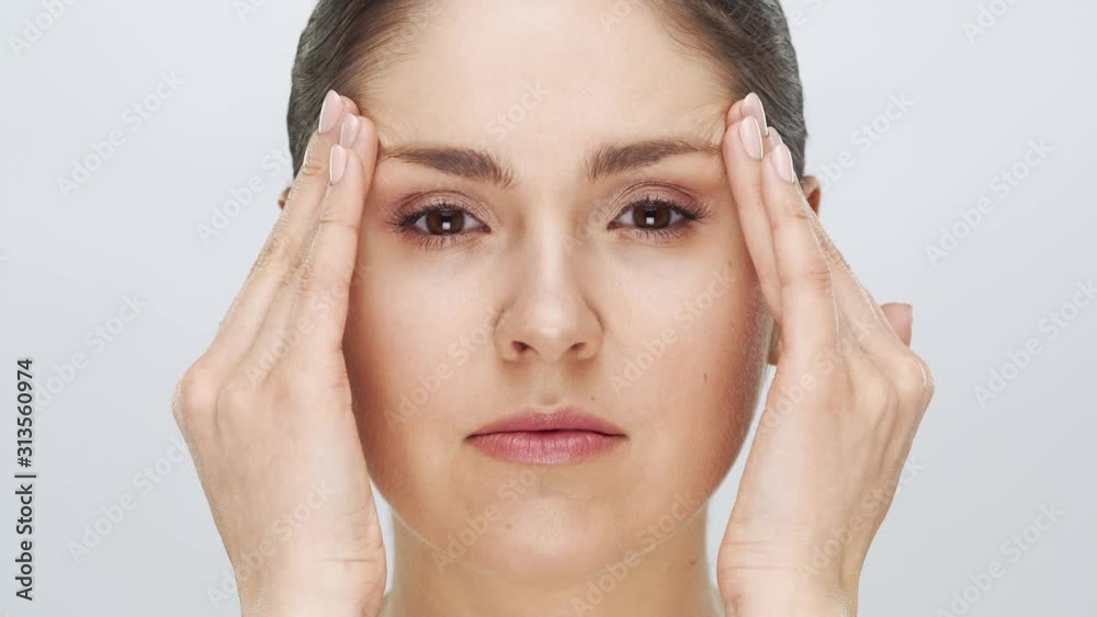 Studio portrait of young, beautiful and natural blond woman applying skin care cream. Face lifting, cosmetics and make-up.