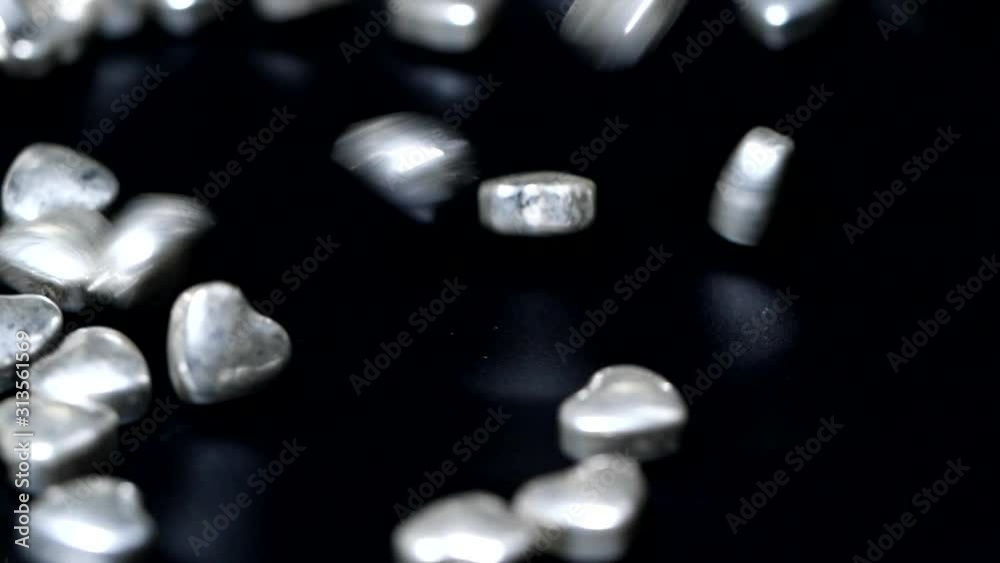 Valentine's Day background with hearts, Silver candies close-up falling in slow motion Valentine's Day background with hearts, Silver candies close-up falling in slow motion