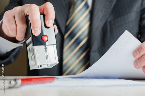 A lawyer or notary puts a seal on the document. A stamp in a man's hand.