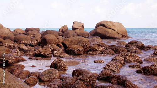 Tropical beach, boulders on the beach, cloudy blue sky, Karon beach, Phuket, Thailand