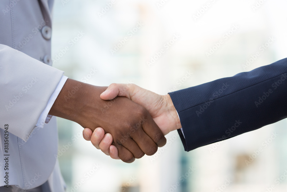 Multiethnic female leaders greeting each other in city. Closeup of business women shaking hands outside. Contract or job concept Multiethnic female leaders greeting each other in city. Closeup of business women shaking hands outside. Contract or job concept