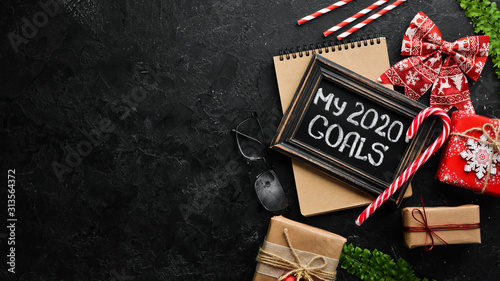 My goals 2020 text with office tools on a black desk. Top view. Free space for your text.