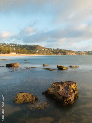 Long exposure view of rocks and water on the coastline.