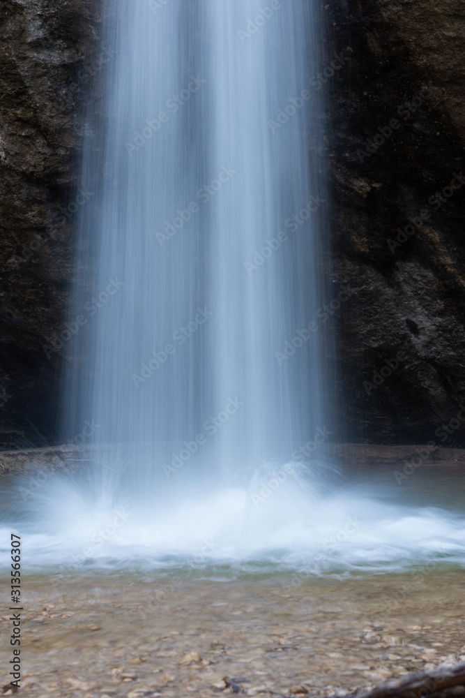 Waterfall in winter in the forest vertical format