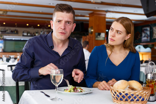 Couple demonstrating dissatisfaction in restaurant
