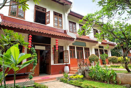 Classic house with Chinese wooden windows and doors decoration, red lanterns and trees