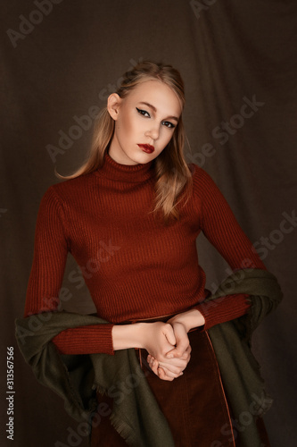 girl in a beautiful brown fur coat posing in the Studio on a brown background