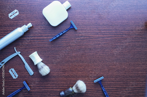 Shaving accessories on a wooden texture background. Tools. Disposable shaving machine, brush, foam and hazard razor.