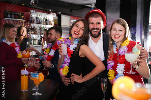 Man with female friends on Hawaiian party in bar