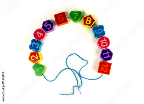 Colorful bright educational toys in the form of lacing for children.Educational toys. Bright colorful background. Colorful wooden geometric shapes pattern with numbers on white background. Copy Space.