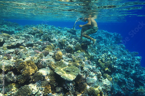 Sailor walks barefoot over corals
