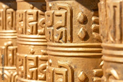 Praying drums. Line of vintage copper praying drums with sanskrit symbols.