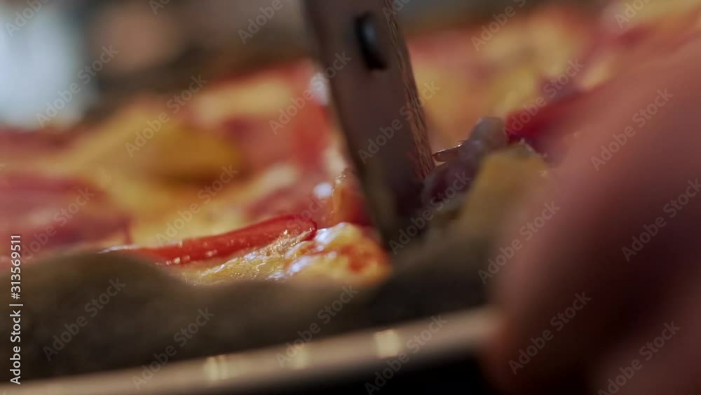 Video with a knife slicing a pizza close up.
