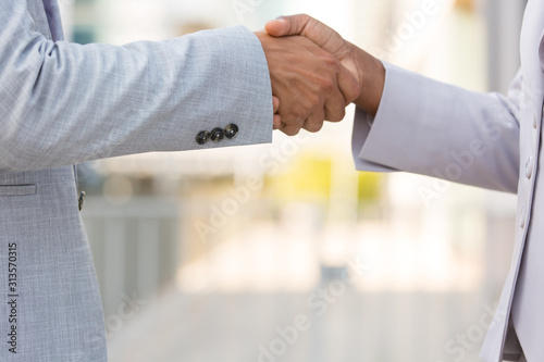 Male and female company representatives greeting each other in city. Closeup of business man and woman shaking hands outside. Collaboration concept